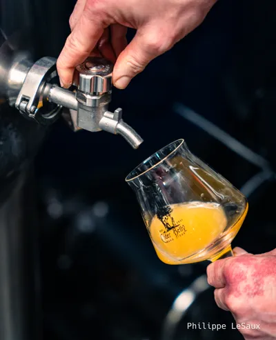 A glass of cider is poured from the barrel